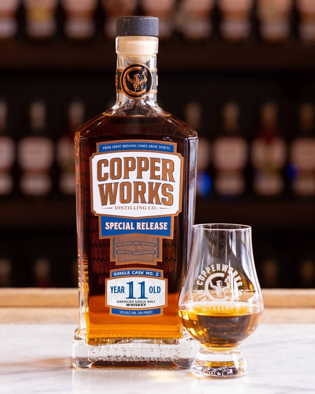 A bottle of Copperworks 11 Year Old Single Cask No. 2 beside a Glencairn glass of whiskey.