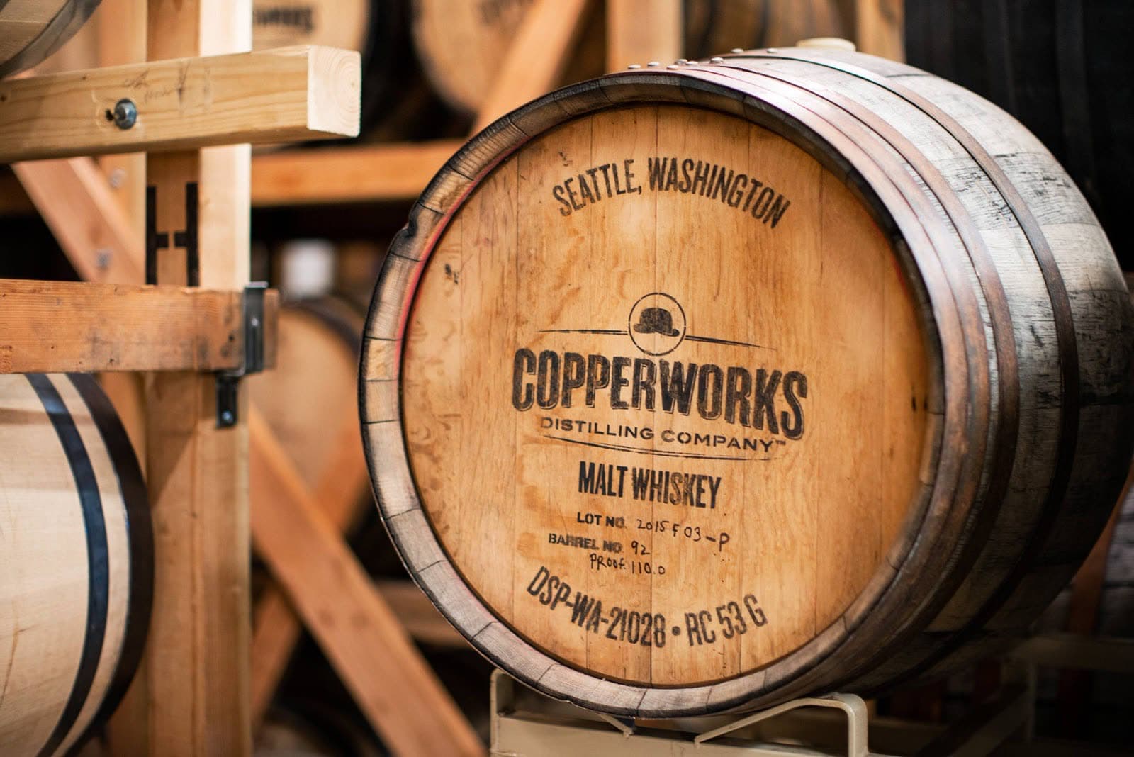A Copperworks malt whiskey cask resting on a rack in the Seattle barrel room, its head stencilled "Seattle, Washington".
